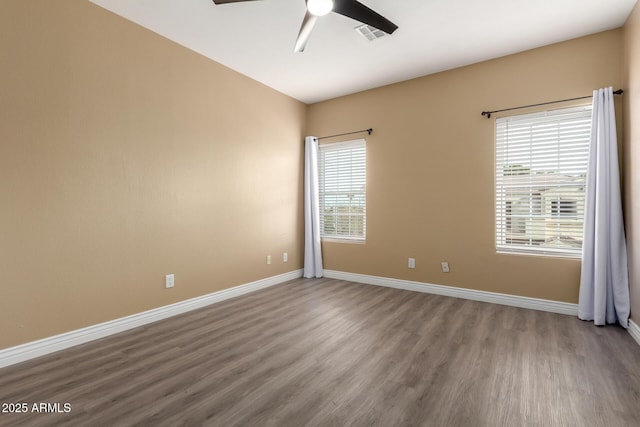 empty room with hardwood / wood-style floors, plenty of natural light, and ceiling fan