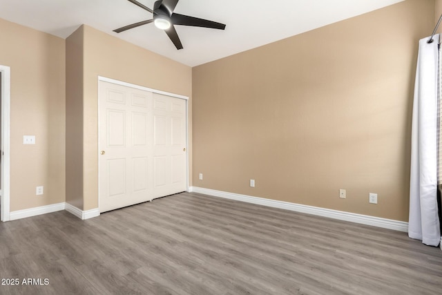 unfurnished bedroom featuring ceiling fan, a closet, and hardwood / wood-style floors