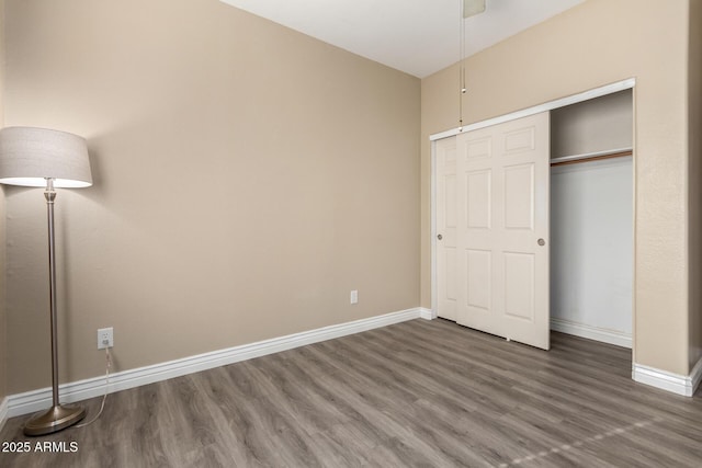 unfurnished bedroom featuring a closet and dark wood-type flooring