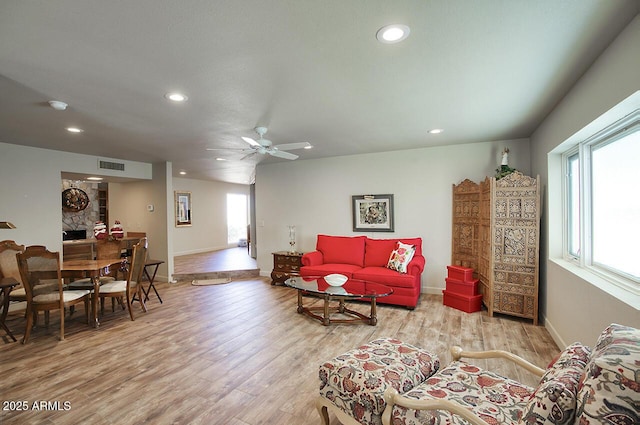 living area with recessed lighting, visible vents, plenty of natural light, and wood finished floors