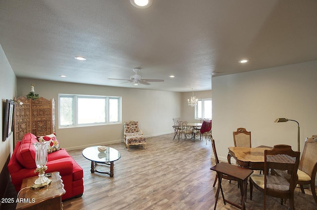 living area with a textured ceiling, recessed lighting, wood finished floors, and baseboards