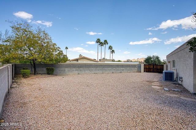 view of yard with a fenced backyard and central AC unit