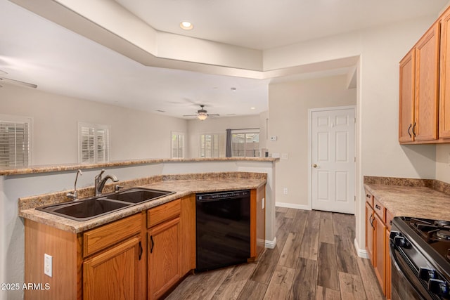 kitchen with baseboards, a ceiling fan, dark wood-type flooring, black appliances, and a sink