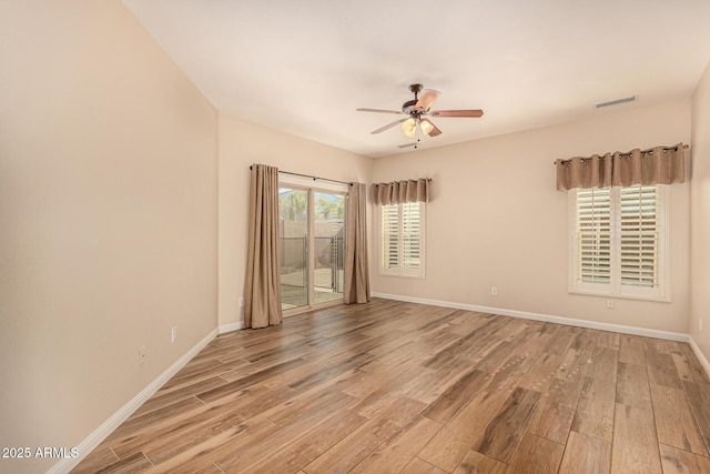 unfurnished room with a ceiling fan, baseboards, and light wood finished floors