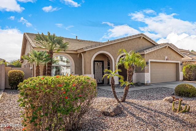 view of front of home with a tiled roof, an attached garage, and stucco siding