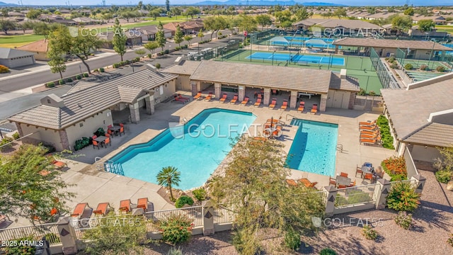 community pool featuring a patio, a residential view, and fence