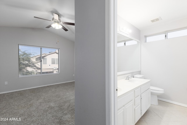 bathroom with tile patterned floors, vanity, vaulted ceiling, ceiling fan, and toilet