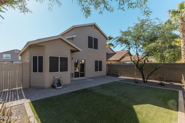 back of property featuring a lawn and a patio