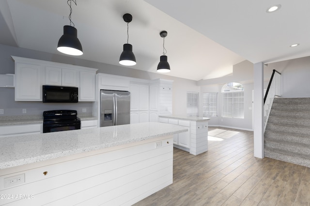 kitchen with light wood-type flooring, light stone counters, black appliances, white cabinetry, and lofted ceiling