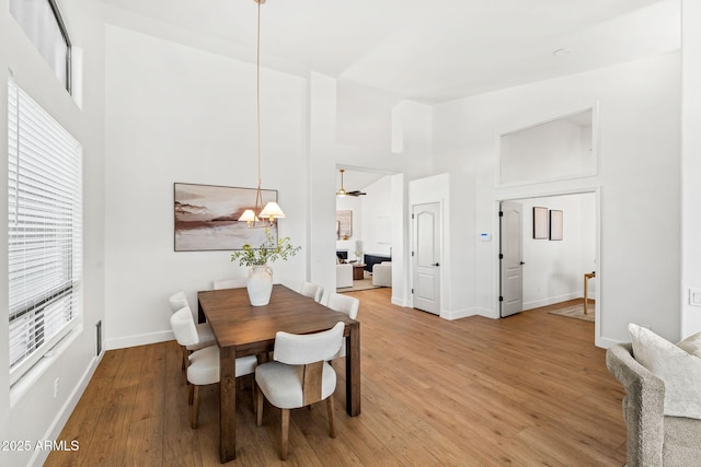 dining room with hardwood / wood-style floors and a high ceiling