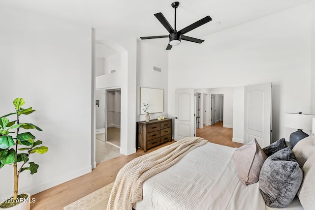 bedroom with ceiling fan, high vaulted ceiling, and light wood-type flooring