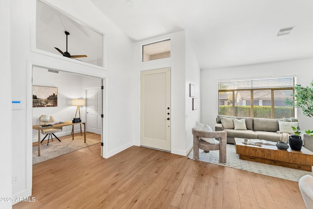 foyer entrance featuring ceiling fan, vaulted ceiling, and light wood-type flooring