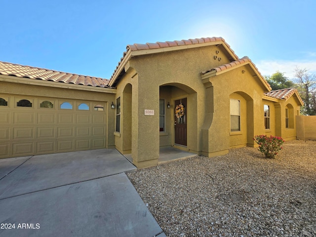 mediterranean / spanish home featuring a garage