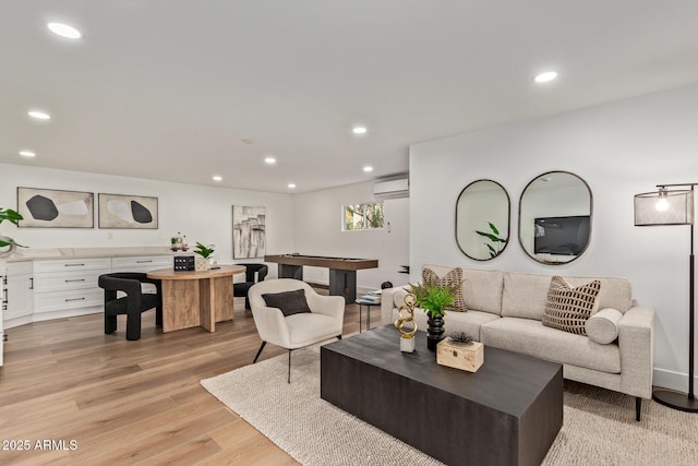 living room with an AC wall unit, recessed lighting, and light wood-style floors