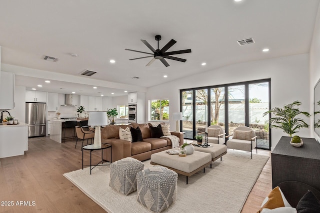 living area with visible vents, a healthy amount of sunlight, light wood-style flooring, and a ceiling fan