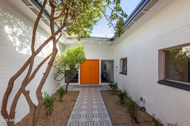 entrance to property featuring brick siding