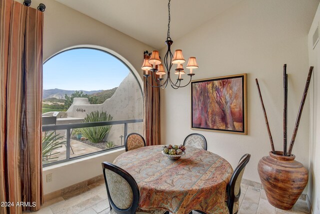 dining area with baseboards, a healthy amount of sunlight, vaulted ceiling, and a notable chandelier