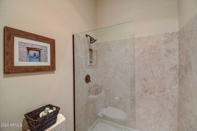 full bath featuring toilet and tiled shower