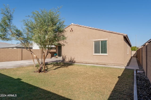 view of side of property with a yard and a patio