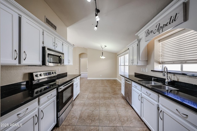 3897 E Douglas Loop, Gilbert, AZ 85234 - kitchen featuring appliances with stainless steel finishes, dark countertops, arched walkways, light tile patterned flooring, and vaulted ceiling