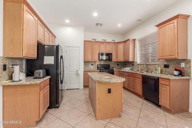 kitchen with light stone counters, a kitchen island, and black appliances