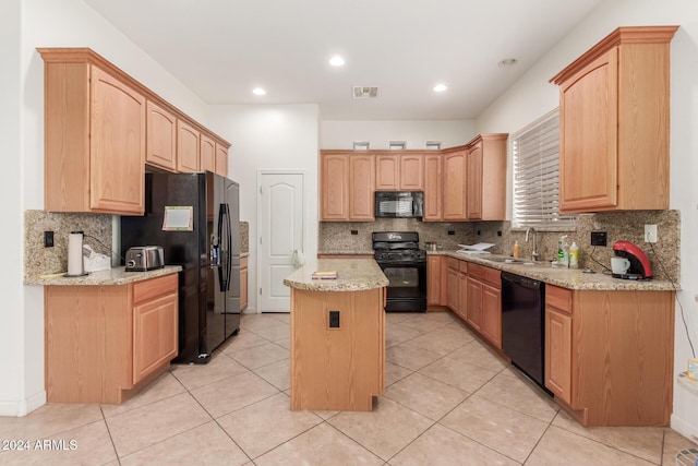 kitchen featuring backsplash, light stone counters, a kitchen island, and black appliances