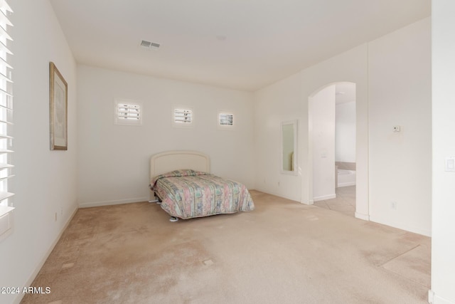 carpeted bedroom with ensuite bath