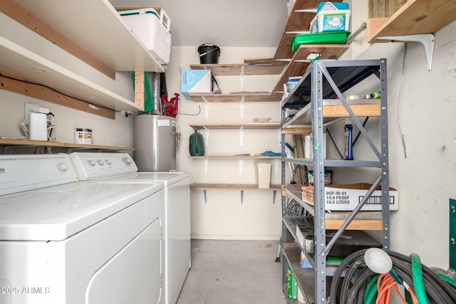 washroom with laundry area, water heater, and washing machine and clothes dryer