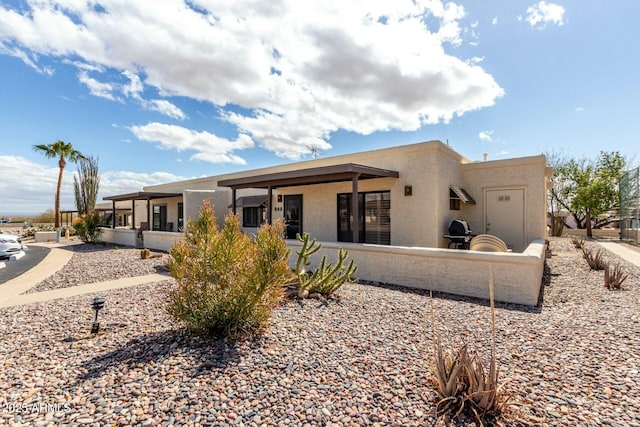 back of house featuring a patio area and stucco siding