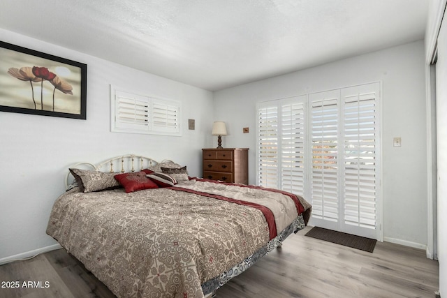 bedroom with baseboards and wood finished floors