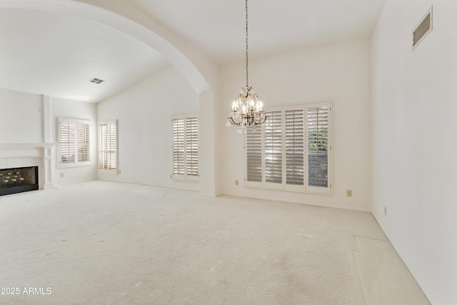 10609 E Cedar Waxwing Dr, Sun Lakes, AZ 85248 - unfurnished living room featuring arched walkways, vaulted ceiling, visible vents, carpet floors, and a notable chandelier