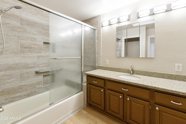 10609 E Cedar Waxwing Dr, Sun Lakes, AZ 85248 - bathroom featuring vanity, wood finished floors, and bath / shower combo with glass door