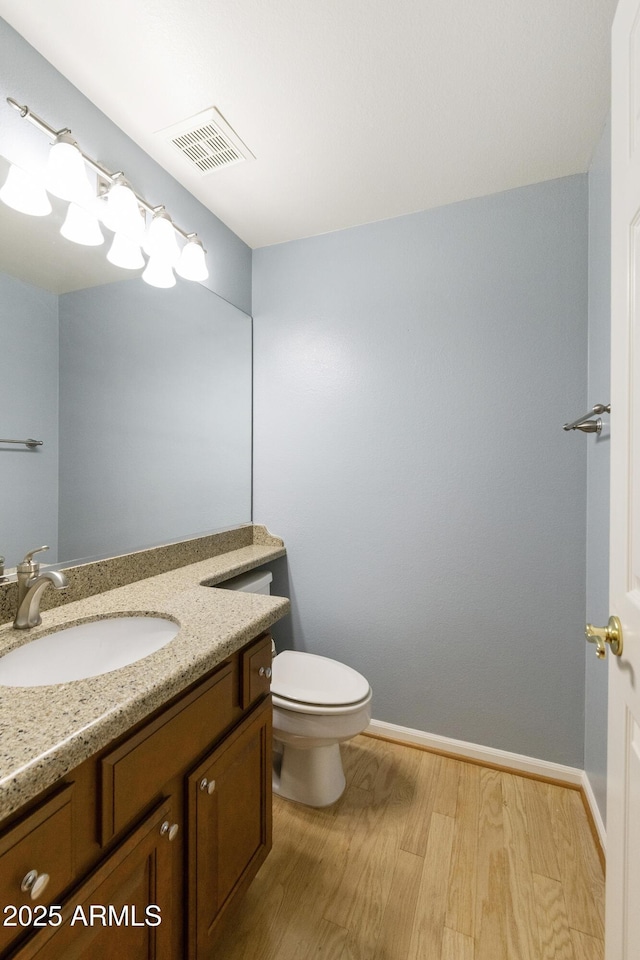 10609 E Cedar Waxwing Dr, Sun Lakes, AZ 85248 - bathroom with vanity, visible vents, toilet, wood finished floors, and baseboards