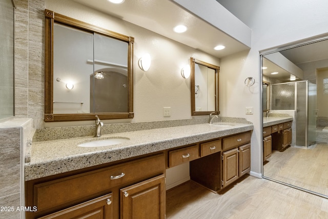 10609 E Cedar Waxwing Dr, Sun Lakes, AZ 85248 - full bathroom with a sink, double vanity, a stall shower, and wood finished floors