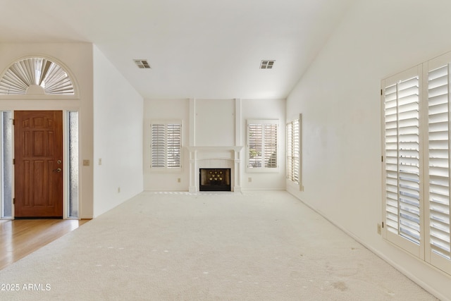 10609 E Cedar Waxwing Dr, Sun Lakes, AZ 85248 - unfurnished living room featuring a fireplace with flush hearth, carpet flooring, and visible vents