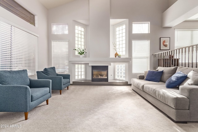 living room featuring carpet flooring and a towering ceiling