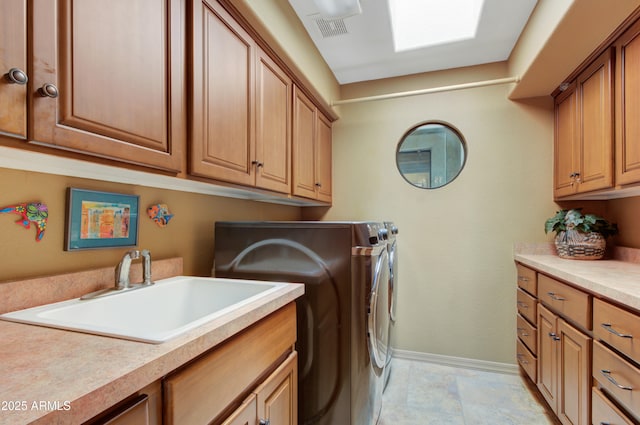 washroom with cabinets, independent washer and dryer, and sink