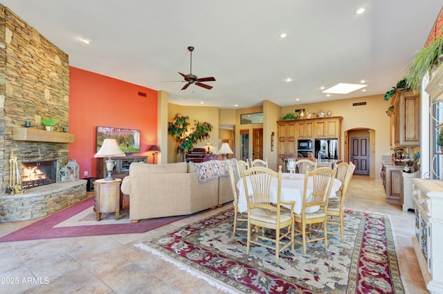 dining area with ceiling fan and a fireplace