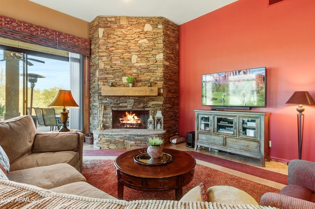 living room featuring vaulted ceiling and a stone fireplace