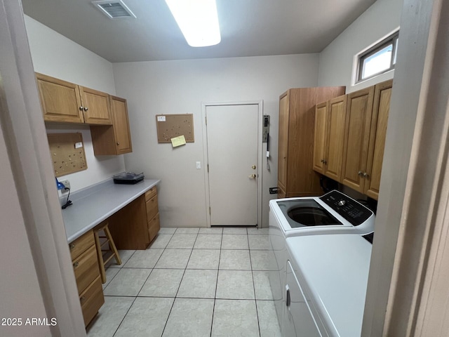 clothes washing area featuring washer and dryer, cabinet space, visible vents, and light tile patterned floors
