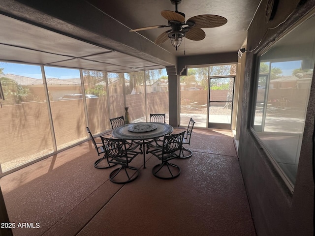 sunroom / solarium featuring outdoor dining area and ceiling fan