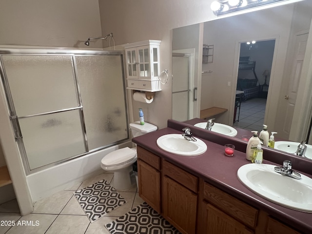 bathroom featuring tile patterned floors, combined bath / shower with glass door, and a sink