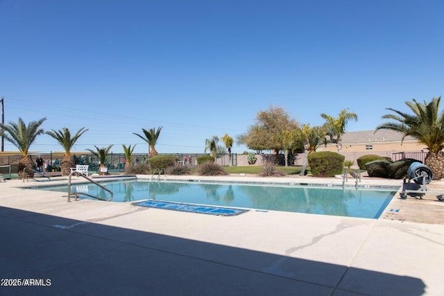 community pool with fence and a patio area
