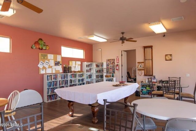 recreation room with wood finished floors, a ceiling fan, and visible vents
