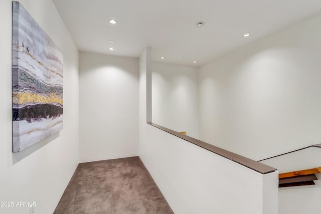 corridor featuring carpet flooring, recessed lighting, and an upstairs landing
