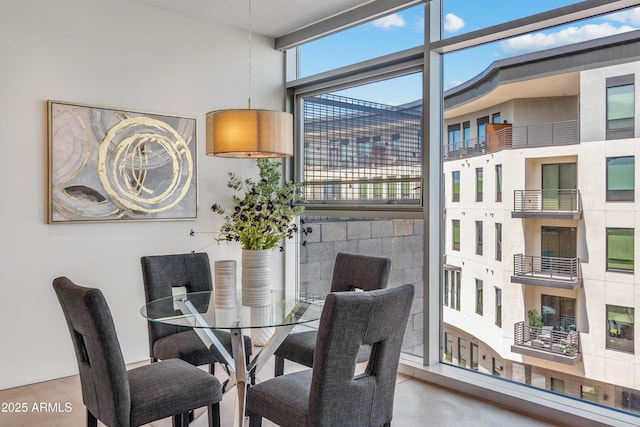 dining room with concrete flooring and a high ceiling