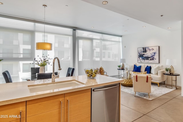 kitchen featuring a sink, stainless steel dishwasher, light tile patterned floors, open floor plan, and pendant lighting