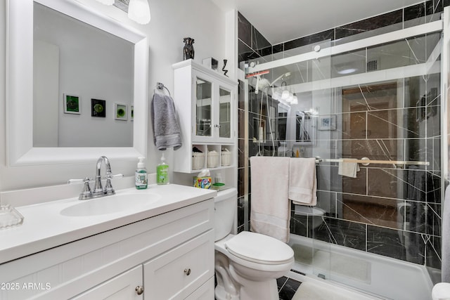 bathroom featuring toilet, walk in shower, and vanity