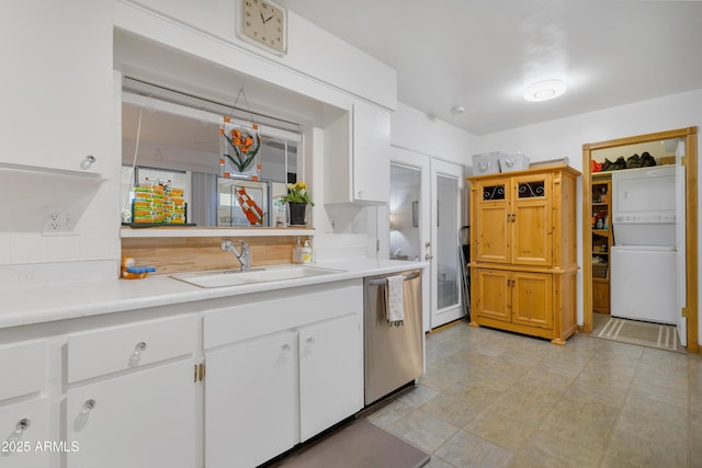 kitchen featuring sink, white cabinetry, dishwasher, and stacked washer / drying machine