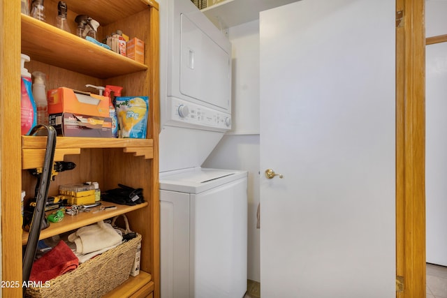 clothes washing area featuring stacked washer and clothes dryer